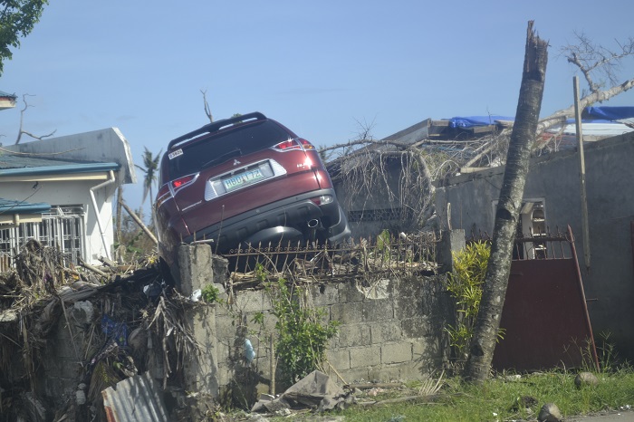Typhoon devestation showing car above wall photo